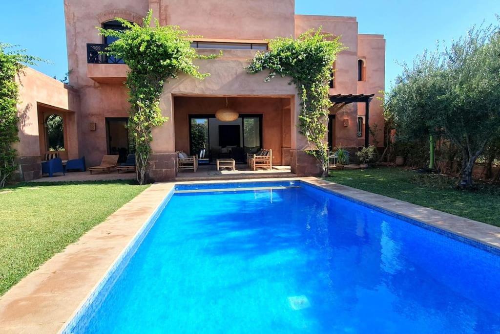 una piscina frente a una casa en Villa avec piscine chauffée (en option) Palmeraie, en Marrakech