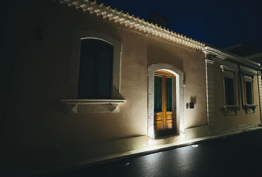 a building with a door and a window at night at Dimore Anna Maria -Il Magazzino- in Avola