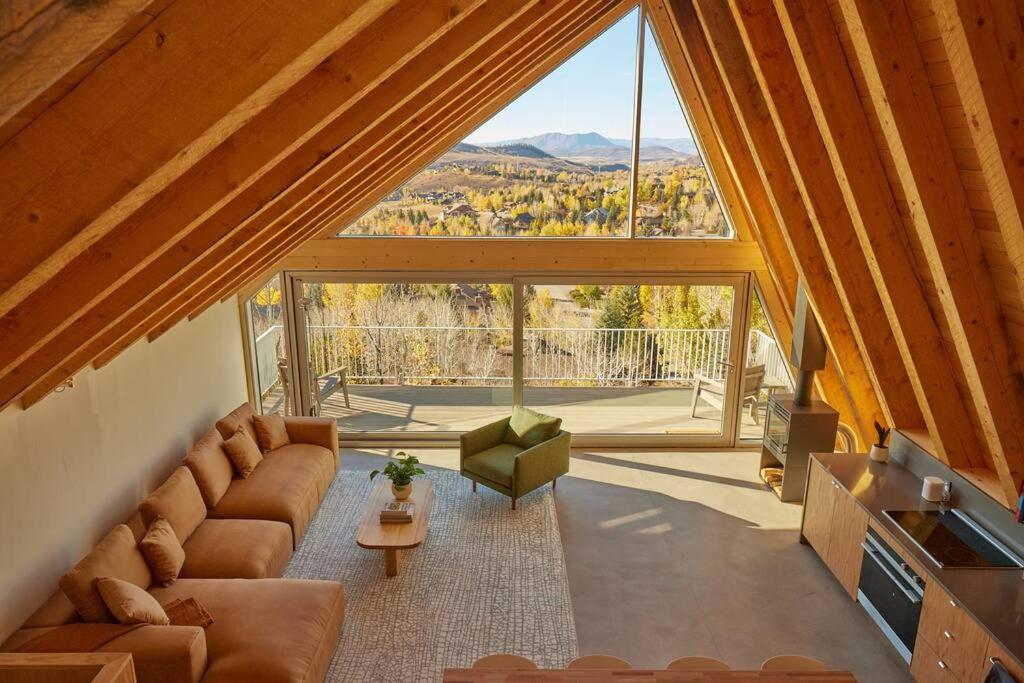 a living room with a couch and a large window at Alpine House #1 in Steamboat Springs