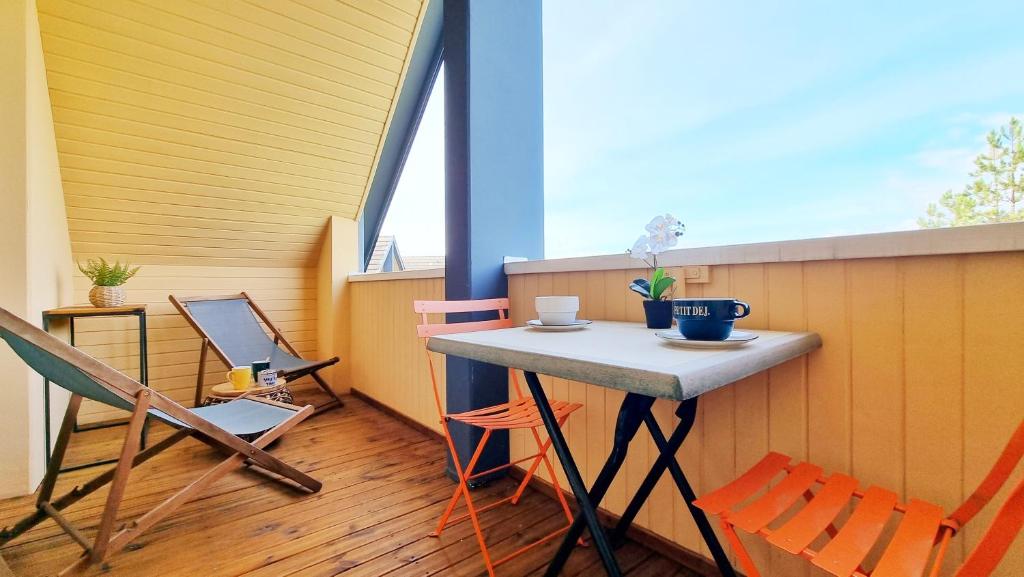 d'un balcon avec une table, des chaises et une fenêtre. dans l'établissement L'Evasion - Balcon - Fibre - Calme - RBNB, à Bollwiller