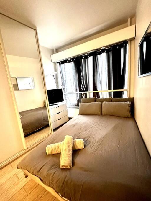 een slaapkamer met een groot bed en een grote spiegel bij Charmant studio Beaugrenelle in Parijs