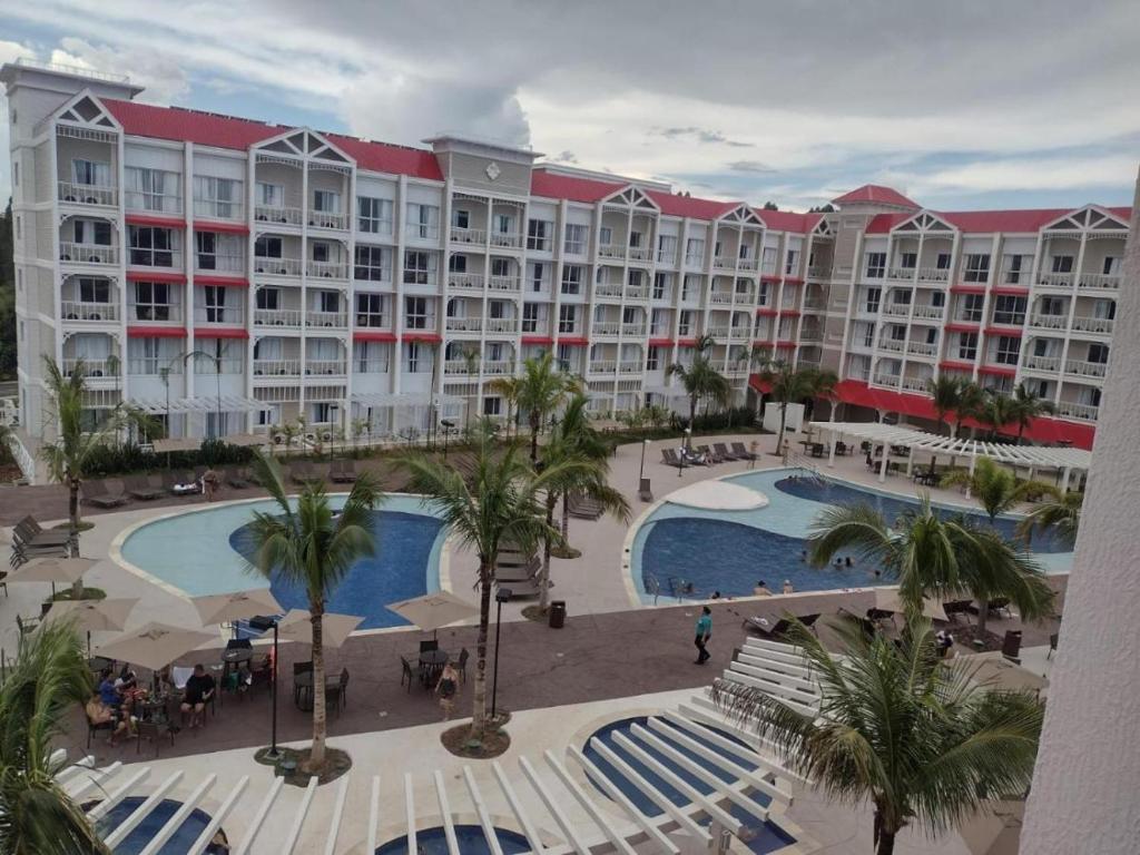 ein großes Hotel mit einem großen Pool und Palmen in der Unterkunft THERMAS SÃO PEDRO RESORT in São Pedro