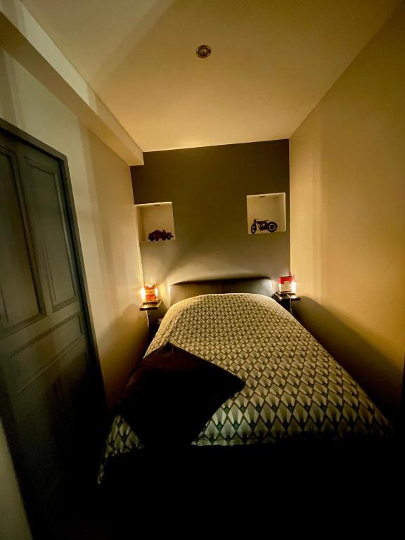 - une chambre avec un lit et deux lumières sur le mur dans l'établissement Le Repos du Vignoble, à Ribeauvillé