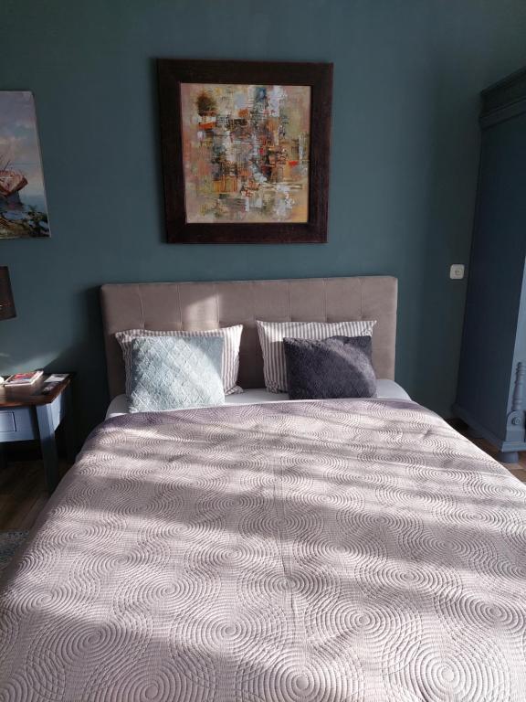 een bed in een slaapkamer met een blauwe muur bij Quiet place in Kaunas