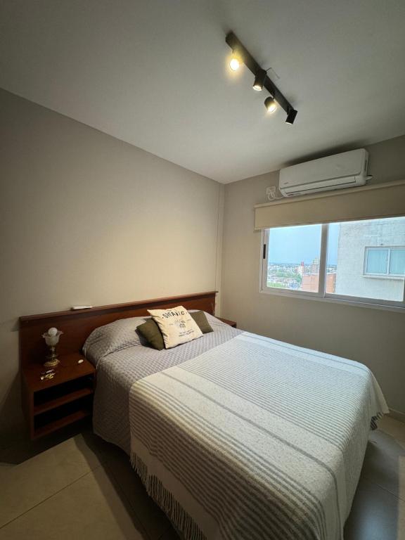um pequeno quarto com uma cama e uma janela em Dpto Santiago Centro em Resistência