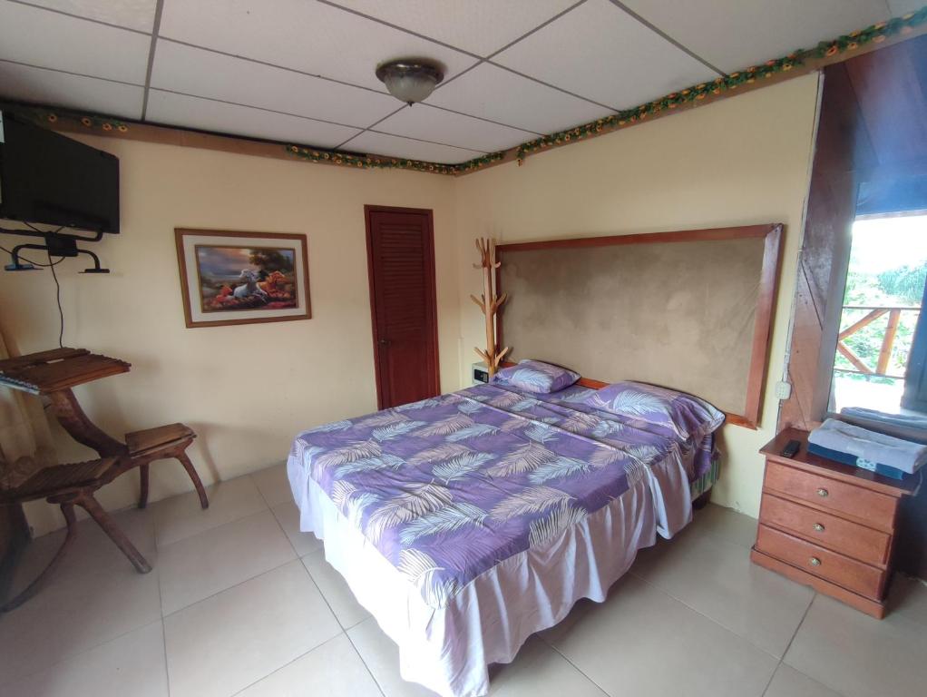 1 dormitorio con 1 cama, vestidor y TV en Hotel Maeo, en Montañita