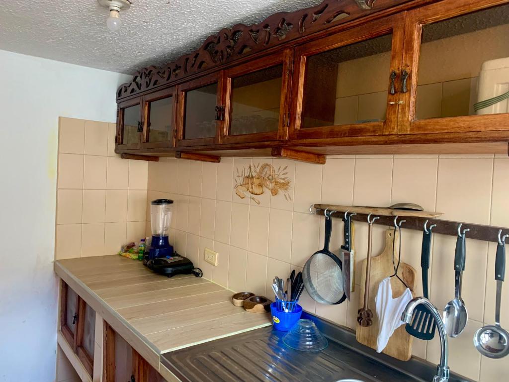 una cocina con armarios de madera y una encimera con utensilios. en Casa Donde Gomez, en Villa de Leyva