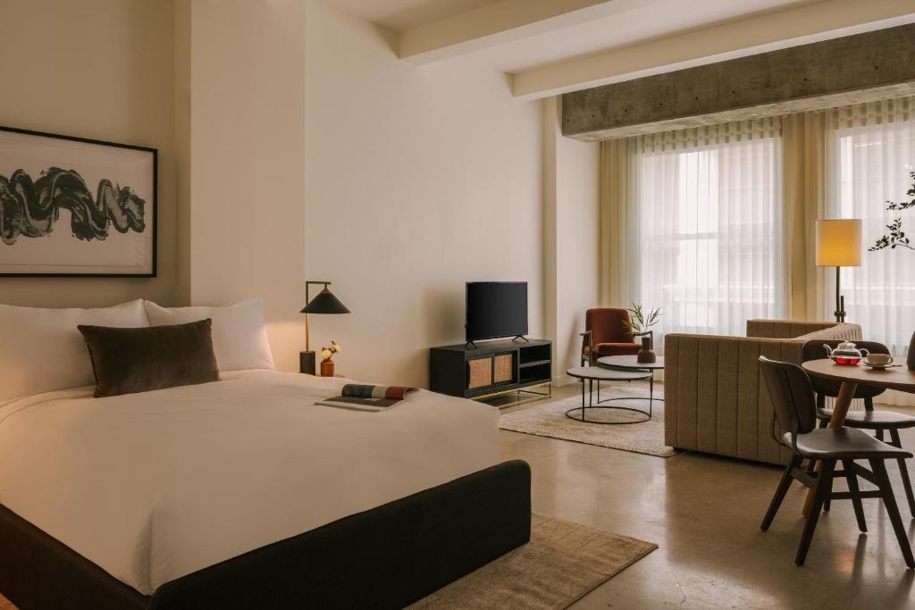 una camera con un grande letto bianco e un soggiorno di Sonder The Craftsman a Los Angeles