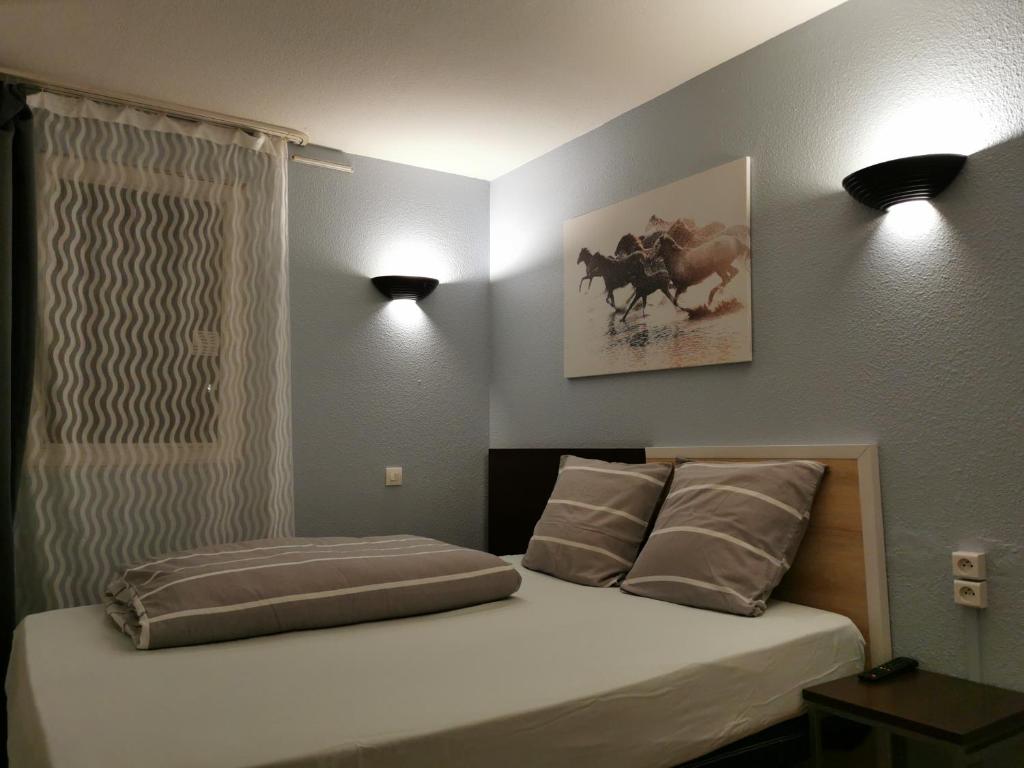 een slaapkamer met een bed met twee lampjes aan de muur bij Appart Hotel La Defense in Courbevoie