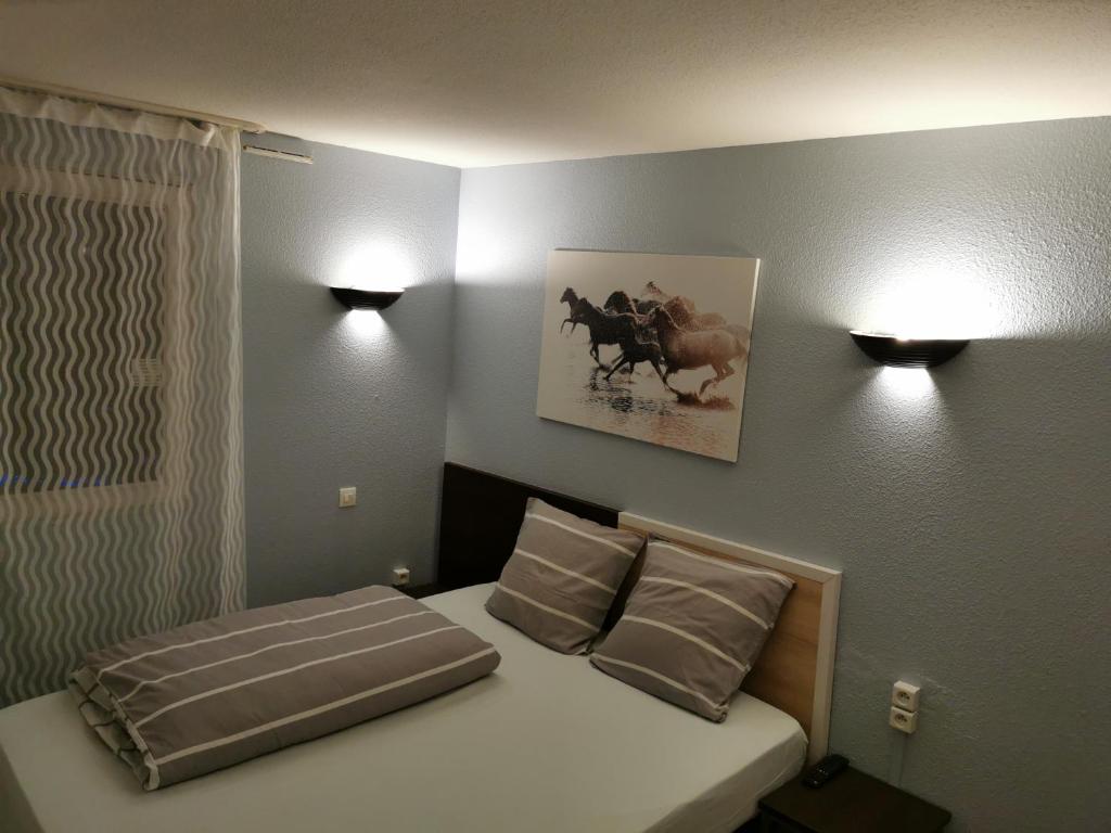 - une petite chambre avec un lit et deux oreillers dans l&#39;établissement Appart Hotel La Defense, à Courbevoie