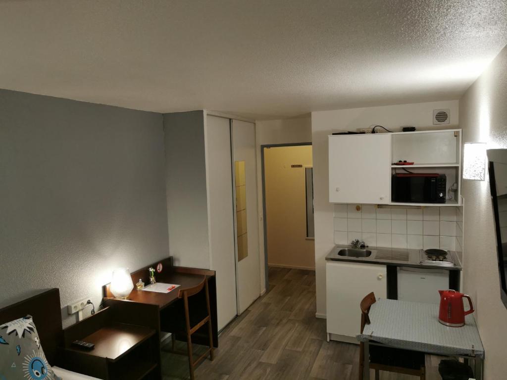 Ce petit appartement comprend une cuisine et une table. dans l&#39;établissement Appart Hotel La Defense, à Courbevoie