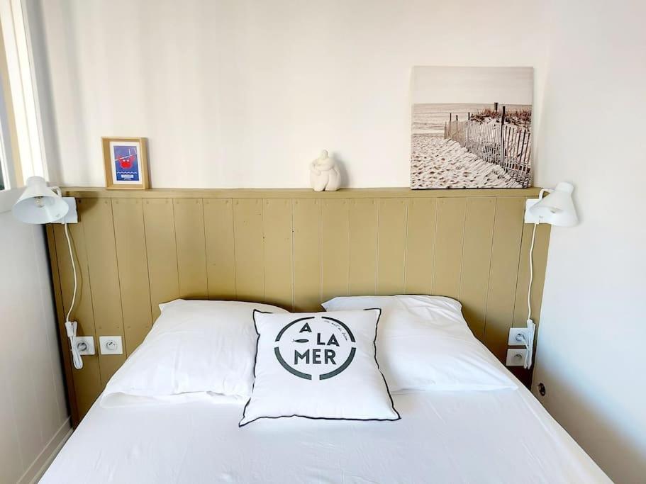ein Schlafzimmer mit einem Bett mit einem Schild drauf in der Unterkunft Le Moth Marseillan in Marseillan