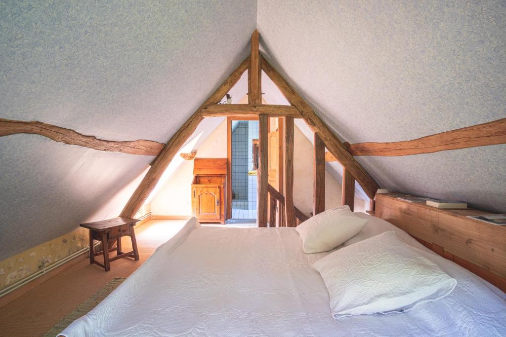 um quarto com uma cama grande num sótão em Domaine Moulin de Boiscorde em Rémalard