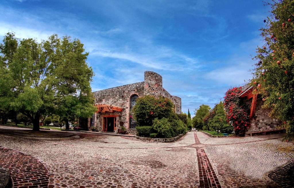 ein großes Steingebäude mit einem Weg davor in der Unterkunft Hotel Hacienda Cantalagua Golf in Contepec