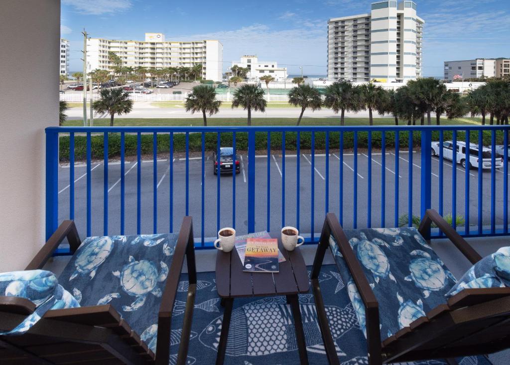 - un balcon avec deux chaises et une table avec un livre dans l'établissement Come Drift Away in this gorgeous coastal themed 2 bed with den and 2 baths condo. OW20-303, à New Smyrna Beach