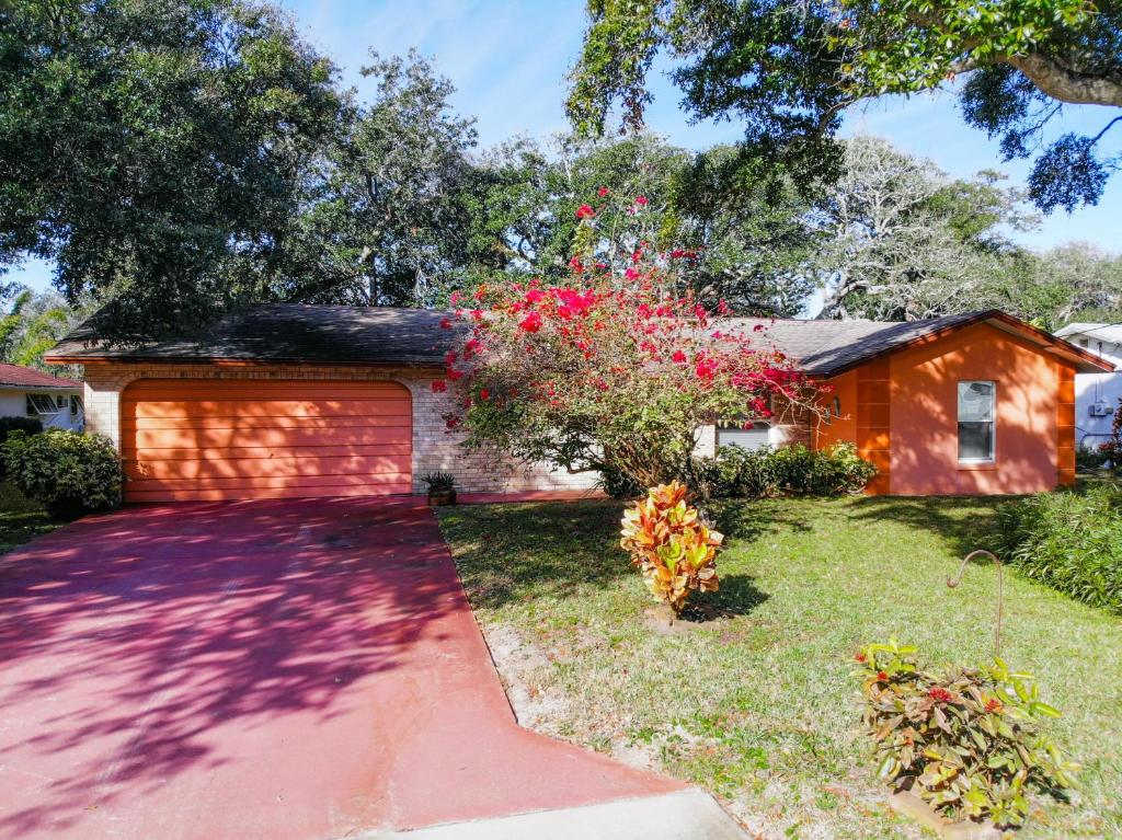 a house with a garage in a yard at Cozy home with 1-car garage within walking distance to the beach. 836C in New Smyrna Beach