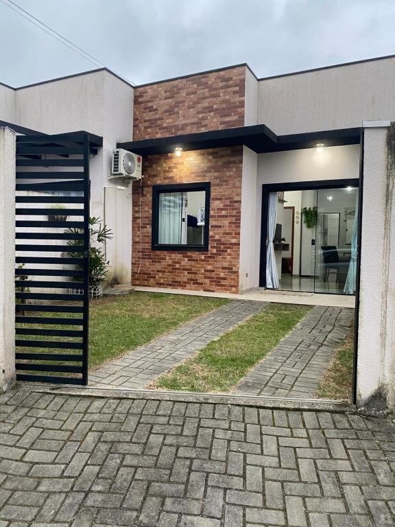a brick house with a garage in front of it at Aconchegante Casa de praia in Matinhos