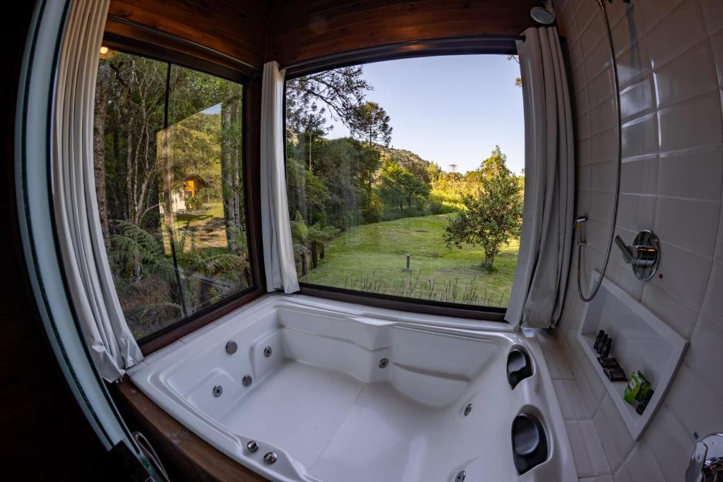 uma banheira na casa de banho com uma janela em La Bella Vista em Urubici