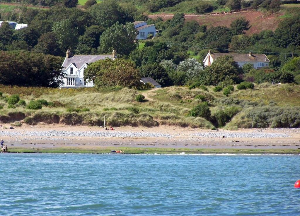 - une vue sur la plage et une maison au loin dans l'établissement Culver House Hotel, à Port Eynon