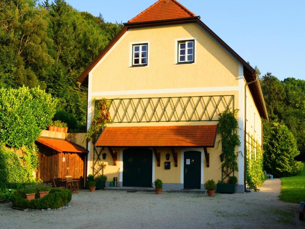 una gran casa amarilla con techo rojo en Pyhra - Urlaub im Elsbeerland, en Wald