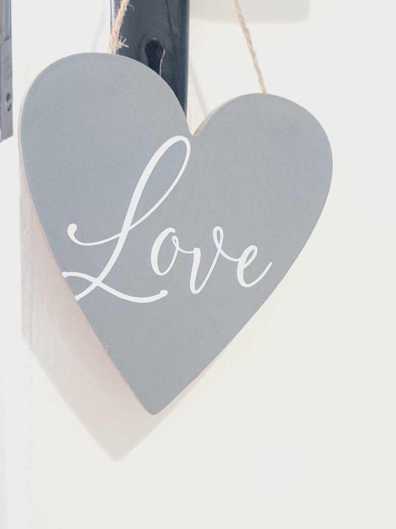 a heart shaped sign with the word love on it at Cliff Cottage in Valtos