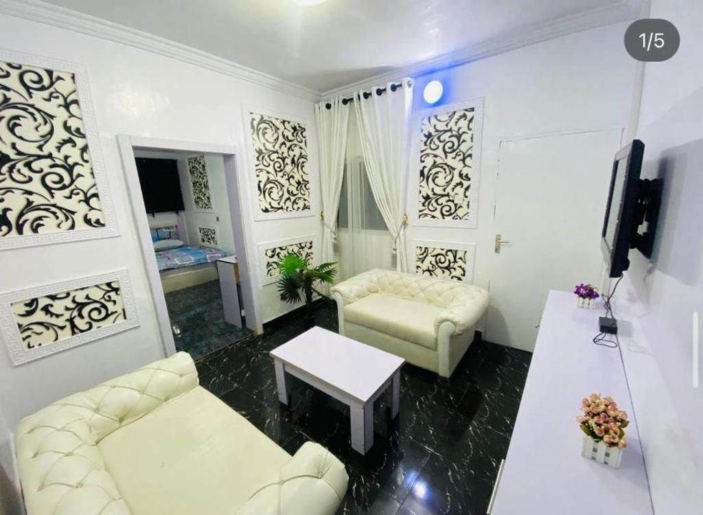 a living room with a couch and a table at White Emirates Hotel and Apartment in Lagos