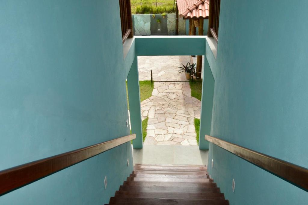 a hallway of a house with blue walls and a sidewalk at Vila Las Hermanas in Pôrto de Pedras