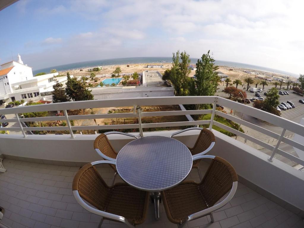 a table on a balcony with a view of the beach at Monte Gordo Prestige Apartments in Monte Gordo