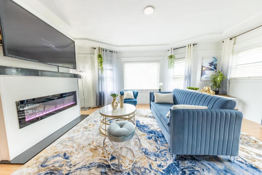 ein Wohnzimmer mit einem blauen Sofa und einem TV in der Unterkunft Cityscape Haven - Central SF Home near SFO in San Bruno