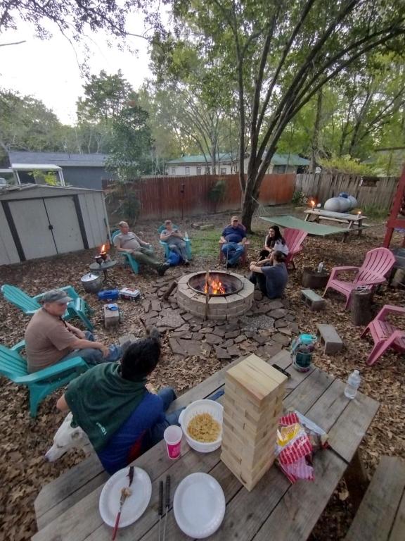 a group of people sitting around a fire pit at Rustic house on Lake Tawakoni in Hawk Cove