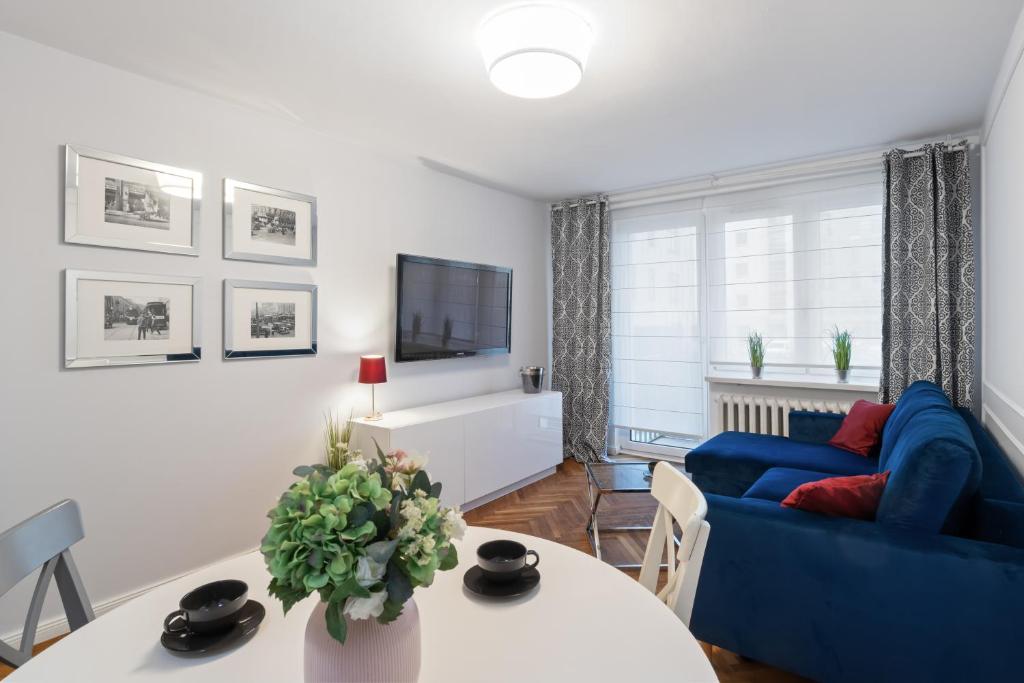 a living room with a blue couch and a table at Apartament Warszawa STARE MIASTO in Warsaw