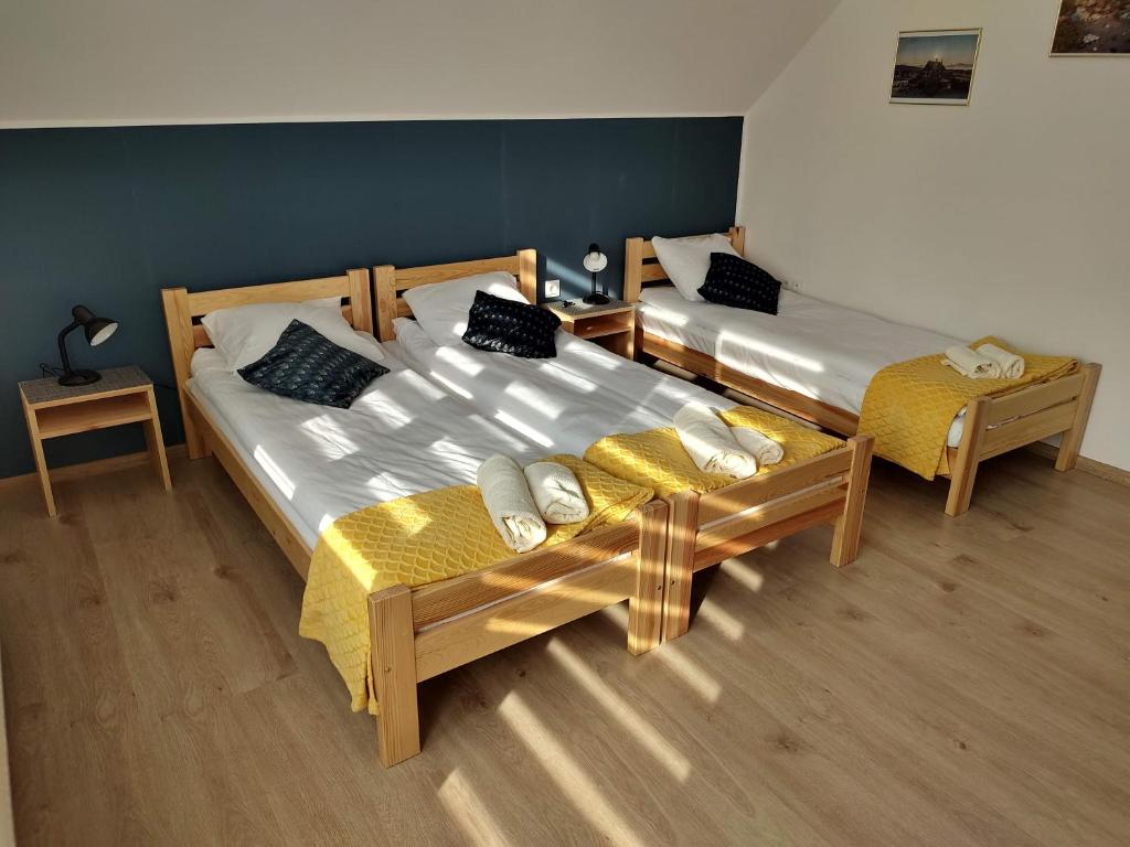 two twin beds in a room with two tables at Apartamenty Starosądeckie in Stary Sącz