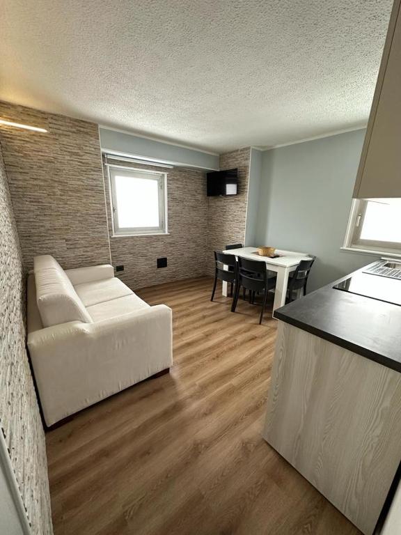 a living room with a white couch and a table at Penelope Home by Casa e Lode in Passo del Tonale