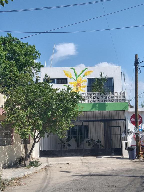 a building with a flower painted on the side of it at Casa Narcisa Studio Apartaments in Mérida