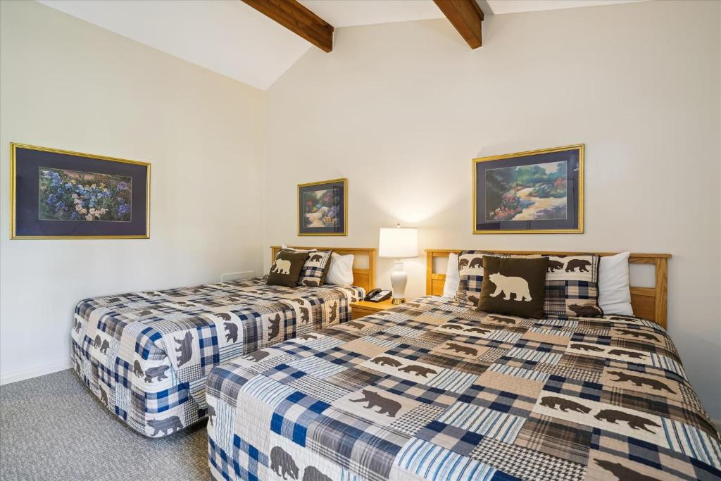 2 camas en una habitación con paredes blancas en Cedarbrook Two Queen Bed Standard Hotel Room with outdoor heated pool 104, en Killington