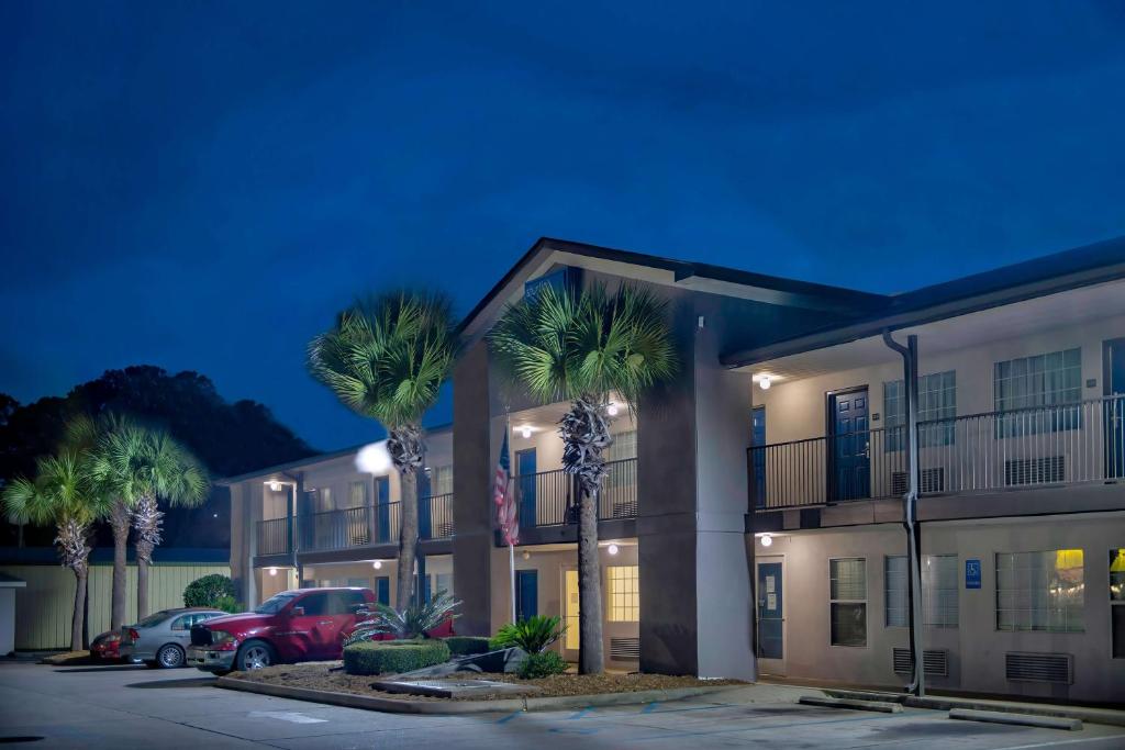 a hotel with palm trees in a parking lot at Studio 6 Extended Stay - Pascagoula, MS in Pascagoula