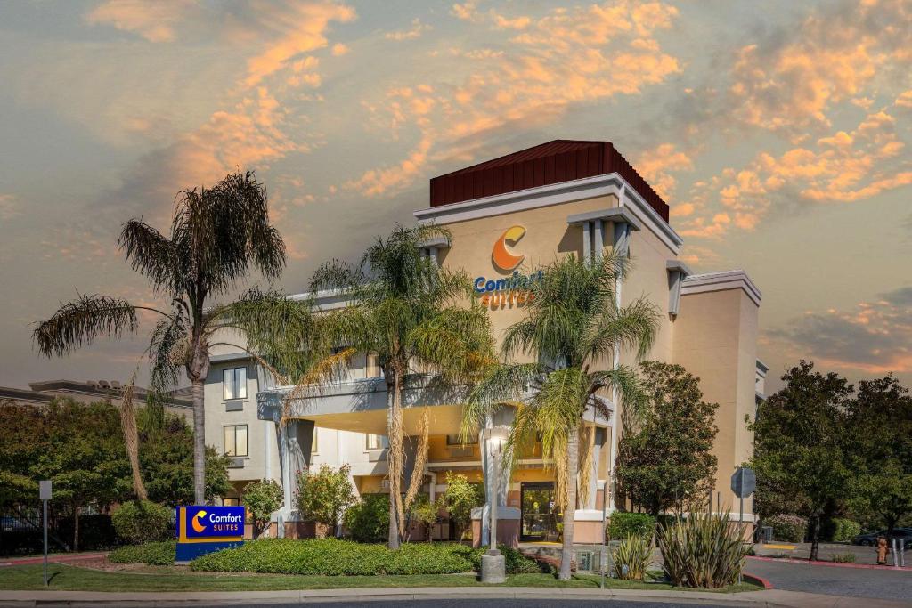 a building with palm trees in front of it at Comfort Suites Vacaville-Napa Valley Area in Vacaville