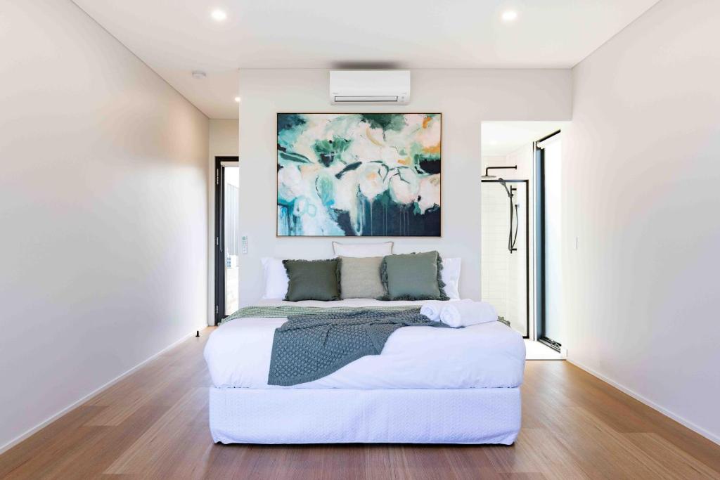1 dormitorio con 1 cama blanca grande y una pintura en la pared en Mt Duneed Estate en Mount Duneed