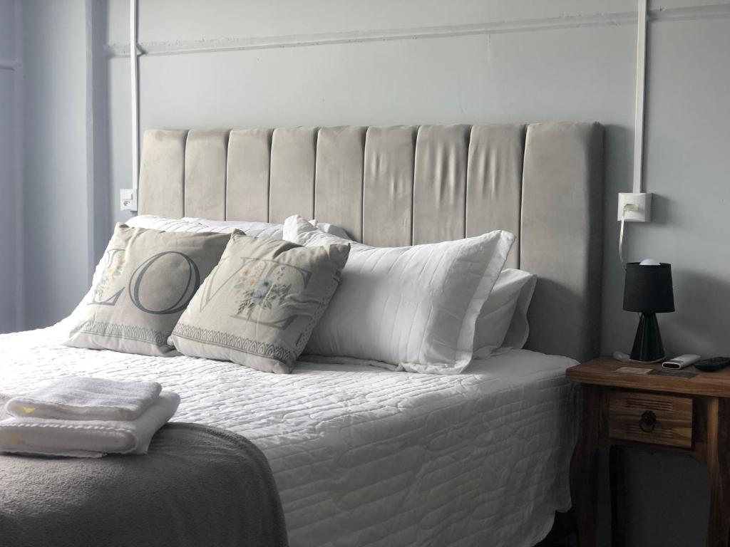 białe łóżko z białą pościelą i poduszkami w obiekcie Morada Pomerode 2 w mieście Pomerode