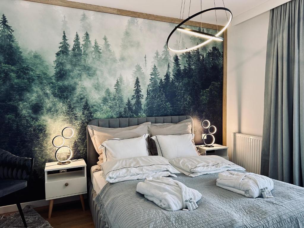 ein Schlafzimmer mit einem großen Gemälde von Bäumen an der Wand in der Unterkunft Mountain Shine - Apartment, SPA and Parking in Zakopane