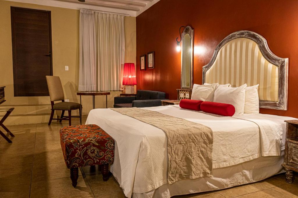 a hotel room with a large bed and a living room at Casa Italia Luxury Guest House - Adults Only in M&eacute;rida