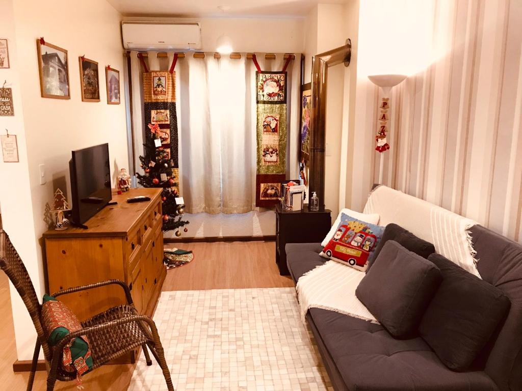 a living room with a couch and a christmas tree at Refúgio na Serra, um espaço para ser desfrutado! in Gramado