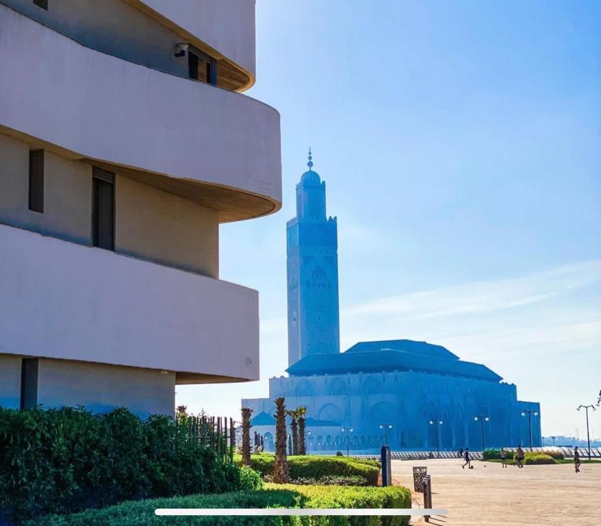 un grand bâtiment avec une tour d'horloge en arrière-plan dans l'établissement Appartement Ocean View - Marina Casablanca, à Casablanca