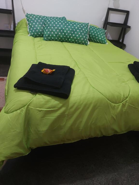 - un lit vert avec des oreillers à point de polka et une chemise dans l'établissement Complejo PG HENTAI, à Jesús María