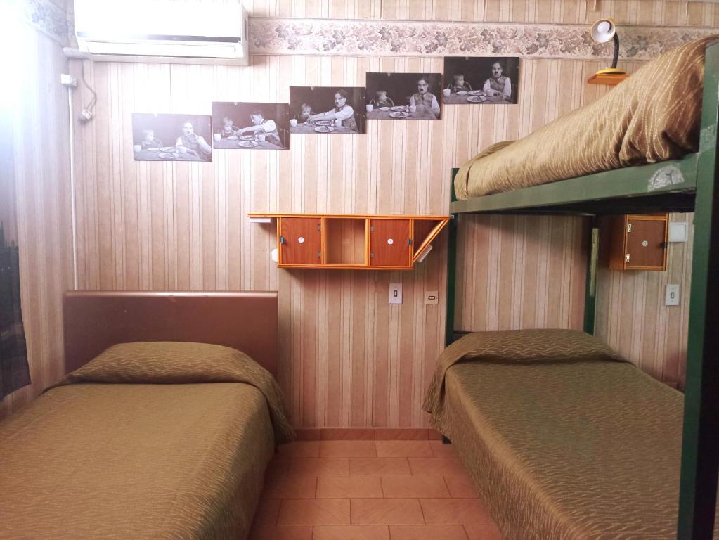 2 literas en una habitación con fotos en la pared en "C" SPACIO HOSTEL - Habitación Compartida por separado para femenino o masculino- en Mendoza