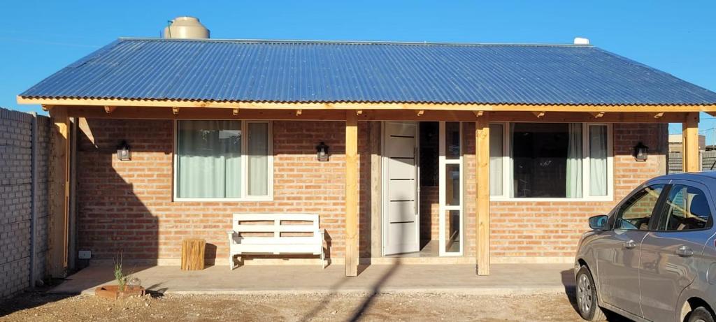 uma casa de tijolos vermelhos com um telhado solar azul em Casa de Playa em Playas Doradas