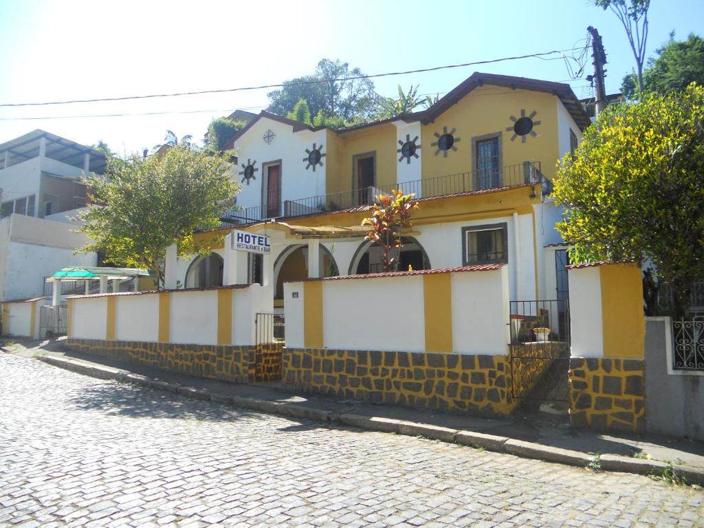ein gelbes und weißes Haus auf einer Kopfsteinpflasterstraße in der Unterkunft Hotel Madrid in Mendes