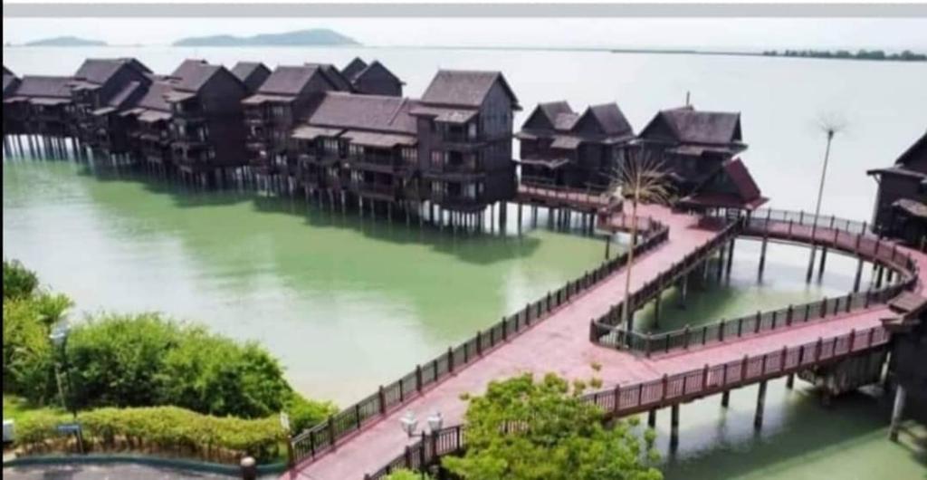 a row of houses on a bridge in the water at Villa Dalam laut 530 in Pantai Cenang
