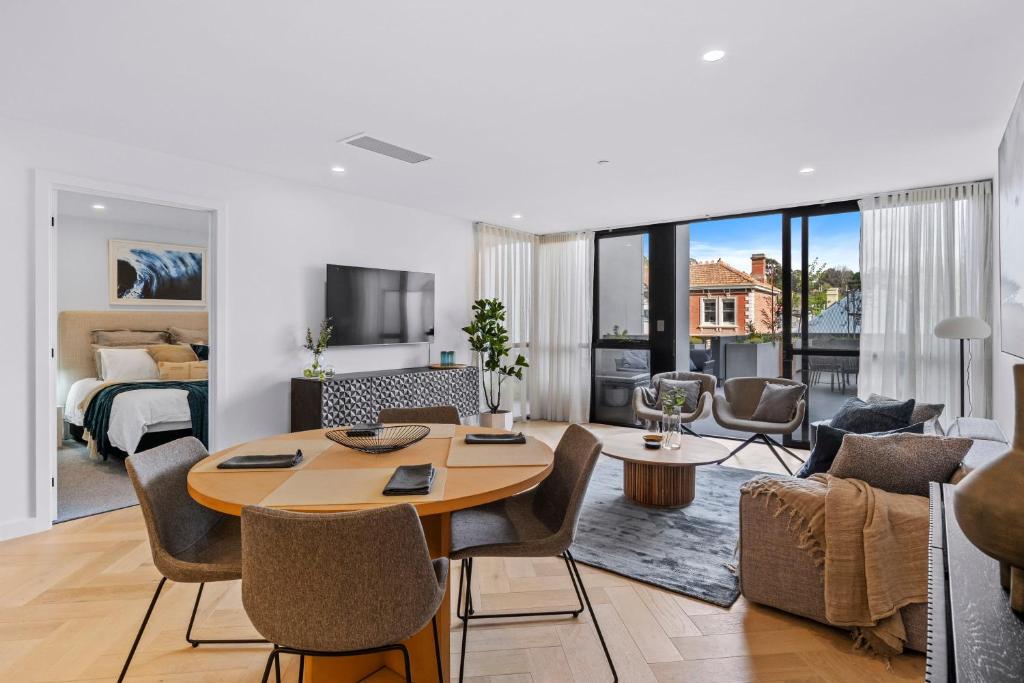 a living room with a table and a living room with a bed at Designer Apartment - giant terrace - city location in Hobart