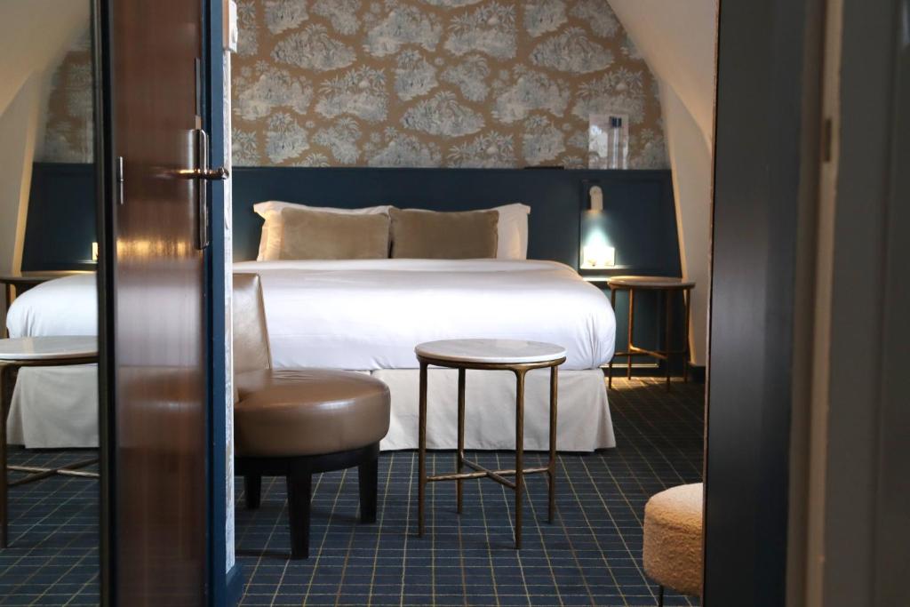 A bed or beds in a room at Le Pergolèse Paris Champs Elysées